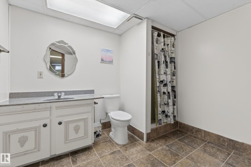 Full bathroom featuring a white vanity with decorative paneling, a gray stone-finish countertop, a single basin sink, and a toilet - 33 Glen Meadow Crescent, St. Albert, AB - Indoor Photo Showing Bathroom