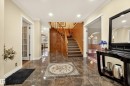 Entryway featuring polished stone tile flooring with an intricate mosaic inlay, a curved wood staircase, recessed lighting, and crown molding - 33 Glen Meadow Crescent, St. Albert, AB  - Indoor Photo Showing Other Room 