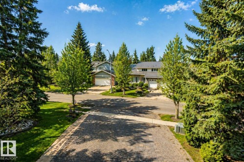 Paved driveway entrance with mature evergreen trees and manicured lawns - 33 Glen Meadow Crescent, St. Albert, AB - Outdoor