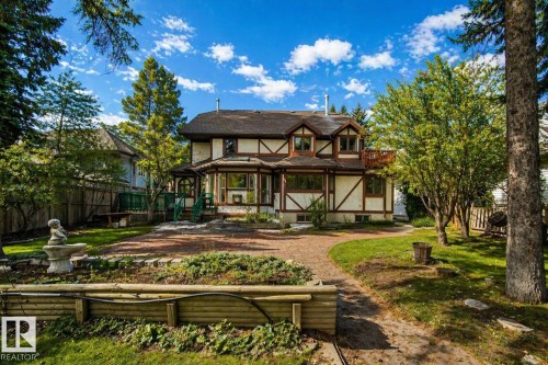 Two-story Tudor-style residence featuring decorative half-timbering, multiple gables, and a prominent bay window - 33 Glen Meadow Crescent, St. Albert, AB - Outdoor With Deck Patio Veranda