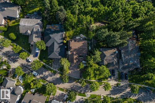 Residential property featuring a dark-toned roof, paved driveway, and mature landscaping - 33 Glen Meadow Crescent, St. Albert, AB - Outdoor With View