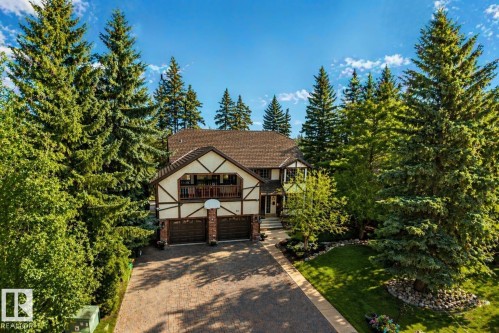 Tudor-style residence featuring a prominent gabled roofline, decorative timber framing, and a two-car garage with brick pillars - 33 Glen Meadow Crescent, St. Albert, AB - Outdoor