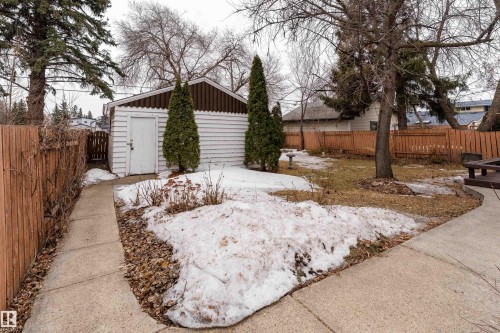 The property features a detached garage with horizontal white siding and a brown trim - 11315 75 Avenue, Edmonton, AB - Outdoor