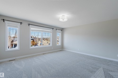 Spacious room featuring light gray carpet flooring and neutral wall tones - 611 176 Street, Edmonton, AB - Indoor