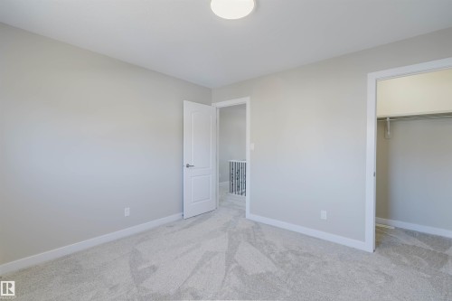 Light-toned wall paint and plush carpeting establish a neutral aesthetic - 611 176 Street, Edmonton, AB - Indoor Photo Showing Other Room
