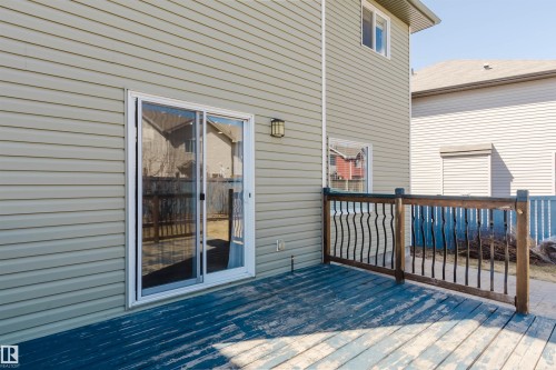 Exterior deck featuring a sliding glass door, decorative metal railing, and horizontal siding - 611 176 Street, Edmonton, AB - Outdoor With Deck Patio Veranda With Exterior