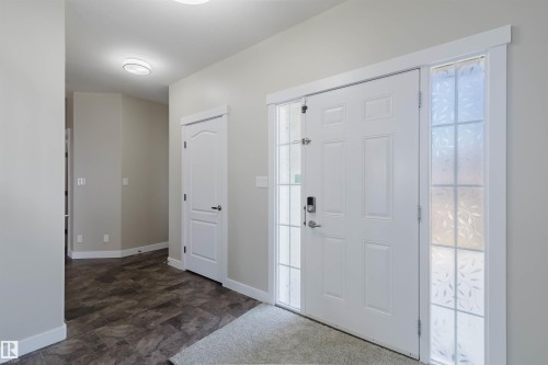 Entryway featuring a white paneled door with frosted sidelight windows, durable wood-finish flooring, and a flush-mount ceiling light - 611 176 Street, Edmonton, AB - Indoor Photo Showing Other Room