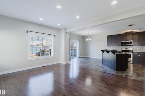 Open-concept living space featuring wood-finish flooring, recessed lighting, and a window with blinds - 611 176 Street, Edmonton, AB - Indoor Photo Showing Kitchen