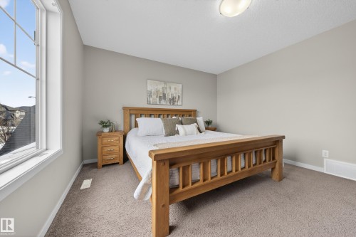 The room features neutral-toned carpet flooring, light gray walls, and a window providing natural light - 2118 52A Street, Edmonton, AB - Indoor Photo Showing Bedroom