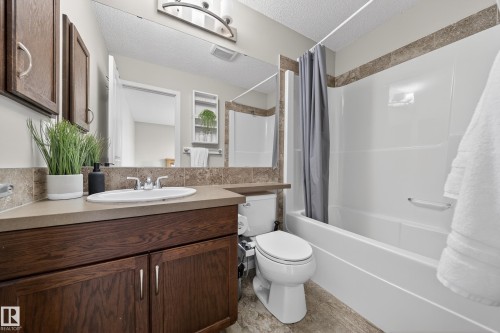 Bathroom featuring a vanity with a countertop and sink, a mirror, and a bathtub with a shower - 2118 52A Street, Edmonton, AB - Indoor Photo Showing Bathroom