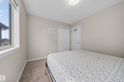 This room features a window providing natural light, neutral-toned walls, and carpeted flooring - 2118 52A Street, Edmonton, AB - Indoor Photo Showing Bedroom