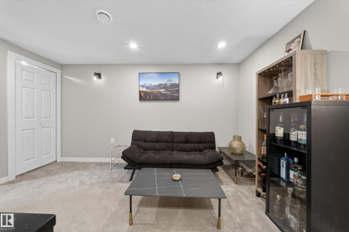 This versatile room features light-colored carpeting, recessed lighting, and a white bi-fold door - 2118 52A Street, Edmonton, AB - Indoor