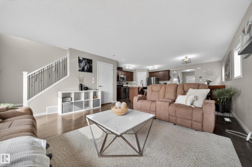 The living area features hardwood flooring, light-toned walls, and overhead lighting - 2118 52A Street, Edmonton, AB - Indoor Photo Showing Living Room