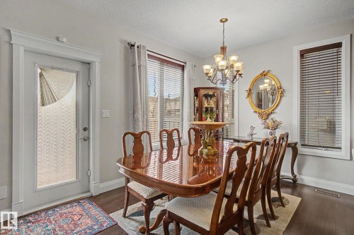 Dining area with wood-finish flooring, featuring a glass-paneled exterior door with decorative privacy film - 805 Hodgins Road, Edmonton, AB - Indoor Photo Showing Dining Room
