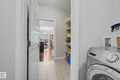 Utility space featuring tile flooring, shelving, and a pantry with additional shelving - 805 Hodgins Road, Edmonton, AB - Indoor Photo Showing Laundry Room