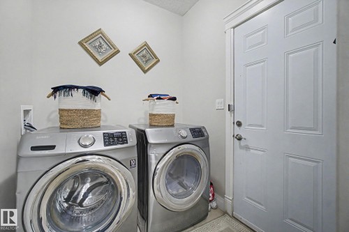 Dedicated laundry area featuring a paneled door, baseboards, and crown molding - 805 Hodgins Road, Edmonton, AB - Indoor Photo Showing Laundry Room