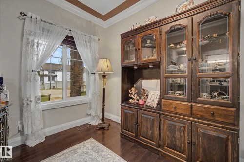 Rich wood-finish cabinetry featuring glass-front display doors and storage drawers - 805 Hodgins Road, Edmonton, AB - Indoor Photo Showing Other Room