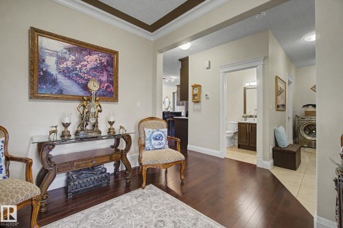 Hardwood-style flooring throughout the entry, featuring crown molding, recessed lighting, and a built-in console table with a glass top - 805 Hodgins Road, Edmonton, AB - Indoor Photo Showing Other Room