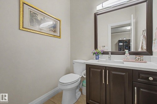 Bathroom vanity featuring dark wood-finish cabinetry, a light-toned countertop, and an integrated sink with a chrome faucet - 805 Hodgins Road, Edmonton, AB - Indoor Photo Showing Bathroom