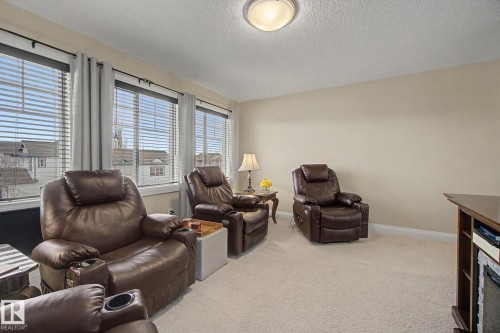 Carpeted room featuring multiple windows with blinds, a ceiling-mounted light fixture, and neutral wall paint - 805 Hodgins Road, Edmonton, AB - Indoor Photo Showing Living Room