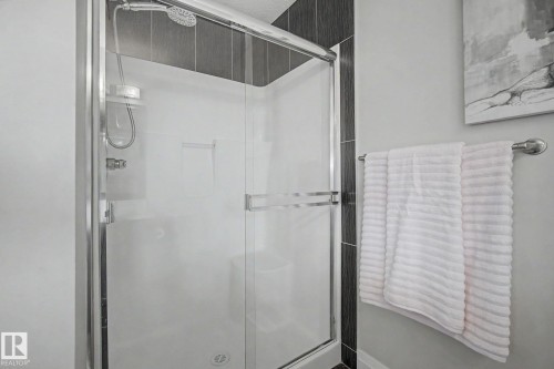 Enclosed shower with clear glass sliding doors and dark gray tile accent wall - 805 Hodgins Road, Edmonton, AB - Indoor Photo Showing Bathroom