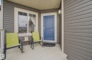 Inviting front porch featuring gray horizontal siding and a contrasting blue entry door - 805 Hodgins Road, Edmonton, AB  - Outdoor With Deck Patio Veranda With Exterior 