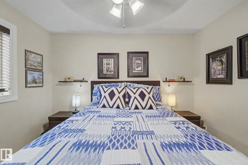 Neutral wall tones with a ceiling fan light fixture - 805 Hodgins Road, Edmonton, AB - Indoor Photo Showing Bedroom