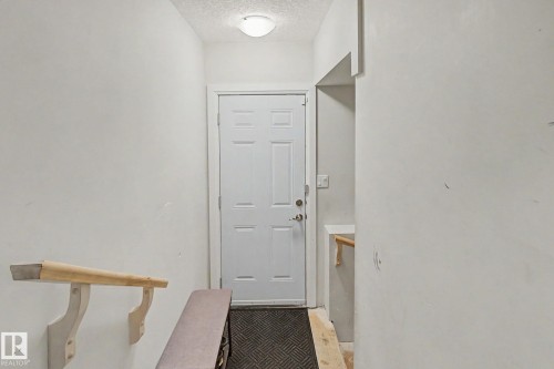 Entryway featuring a paneled door with polished hardware, overhead flush-mount lighting, and neutral wall tones - 805 Hodgins Road, Edmonton, AB - Indoor Photo Showing Other Room
