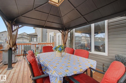 Expansive deck featuring wood-finish flooring, a built-in privacy wall, and a full-size window - 805 Hodgins Road, Edmonton, AB - Outdoor With Deck Patio Veranda With Exterior