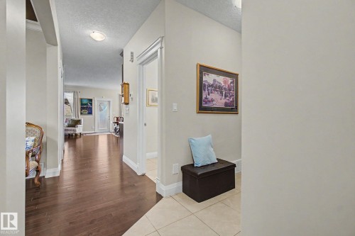 Hallway with dark wood-finish flooring extending into a bright interior space - 805 Hodgins Road, Edmonton, AB - Indoor Photo Showing Other Room