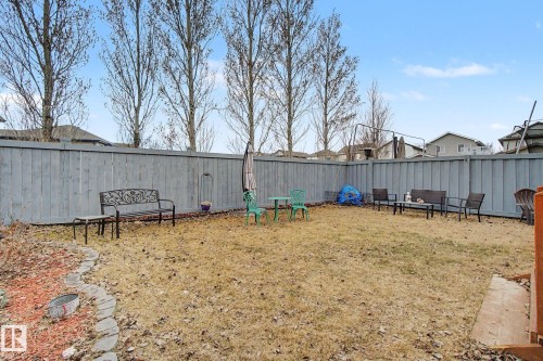 Fenced backyard featuring a gravel path border and multiple mature trees - 805 Hodgins Road, Edmonton, AB - Outdoor