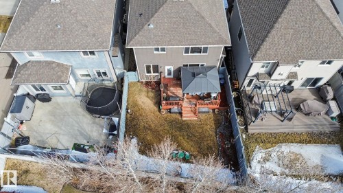 Rear exterior featuring a multi-level wood deck, a patio door, and a partially covered outdoor seating area - 805 Hodgins Road, Edmonton, AB - Outdoor
