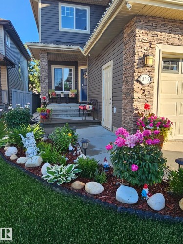 Front exterior featuring stone detailing, horizontal siding, and a covered porch - 805 Hodgins Road, Edmonton, AB - Outdoor With Deck Patio Veranda