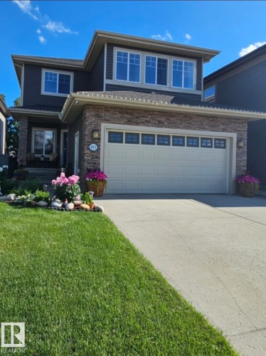 Contemporary two-story residence featuring a dark siding exterior with stacked stone accents - 805 Hodgins Road, Edmonton, AB - Outdoor With Facade