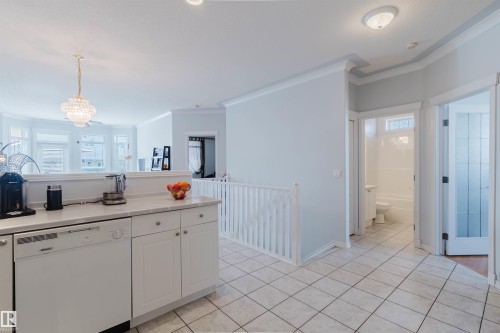 Kitchen area featuring white cabinetry, a built-in dishwasher, and a light-toned countertop - 19 1659 Jamha Road, Edmonton, AB - Indoor Photo Showing Kitchen