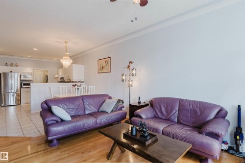 Living area featuring wood-finish flooring, crown molding, and a chandelier lighting fixture - 19 1659 Jamha Road, Edmonton, AB - Indoor Photo Showing Living Room