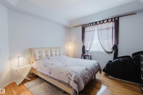 Bedroom featuring polished hardwood flooring and a ceiling tray detail - 19 1659 Jamha Road, Edmonton, AB - Indoor Photo Showing Bedroom