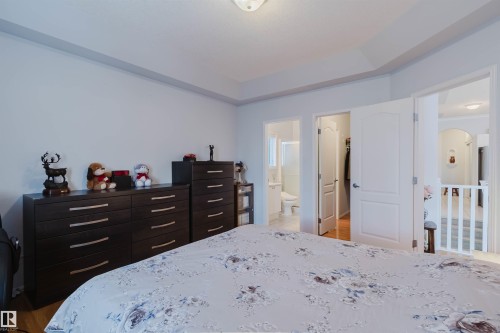 Bedroom featuring wood-finish flooring, a tray ceiling, and light-colored walls - 19 1659 Jamha Road, Edmonton, AB - Indoor Photo Showing Bedroom