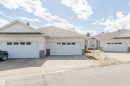 Exterior featuring white siding, brown shingle roofing, and brick veneer accents - 19 1659 Jamha Road, Edmonton, AB  - Outdoor With Facade 