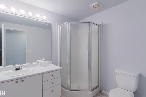 Bathroom featuring a white vanity with integrated sink, chrome faucet, and a large wall-mounted mirror - 19 1659 Jamha Road, Edmonton, AB - Indoor Photo Showing Bathroom