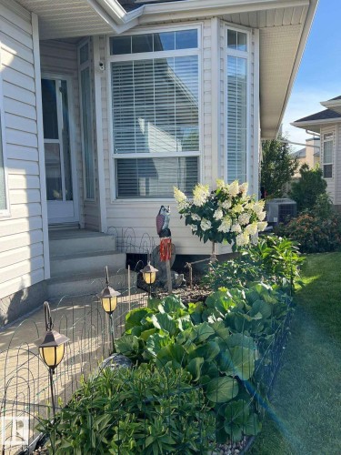 Exterior facade featuring light-colored siding and a multi-paned bay window with blinds - 19 1659 Jamha Road, Edmonton, AB - Outdoor