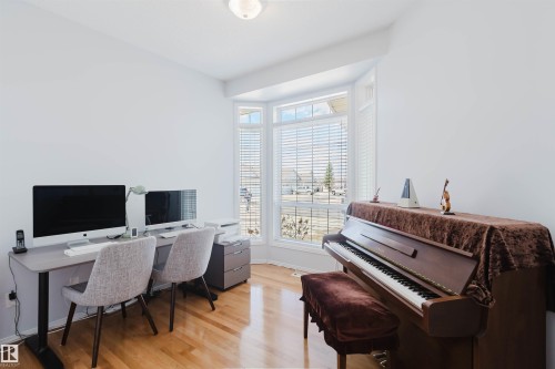 Hardwood flooring throughout this versatile space, featuring a bay window with blinds and bright white walls - 19 1659 Jamha Road, Edmonton, AB - Indoor Photo Showing Office