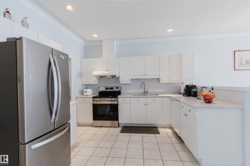 Kitchen featuring white cabinetry, light countertops, and tile flooring - 19 1659 Jamha Road, Edmonton, AB - Indoor Photo Showing Kitchen With Stainless Steel Kitchen