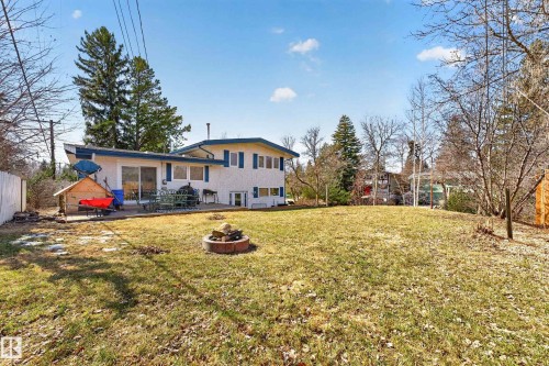 Spacious rear yard with a tiered lawn and a stone fire pit - 1 Greenwich Crescent, St. Albert, AB - Outdoor