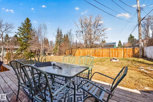 Spacious backyard featuring a wooden deck, a fire pit, and a wooden privacy fence - 1 Greenwich Crescent, St. Albert, AB - Outdoor With Deck Patio Veranda