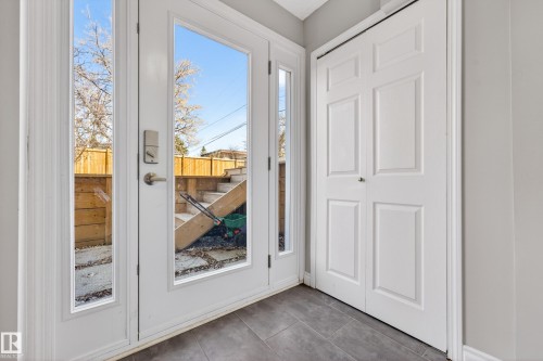Entryway featuring a white paneled door with sidelights, a smart lock, and gray plank-style floor tiles - 1 Greenwich Crescent, St. Albert, AB - Indoor Photo Showing Other Room