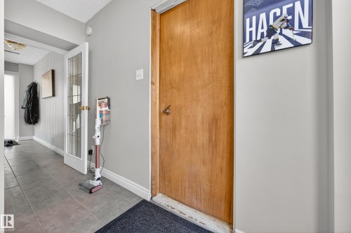 Entryway featuring a wood-panel door, gray wall paint, and white baseboards - 1 Greenwich Crescent, St. Albert, AB - Indoor Photo Showing Other Room