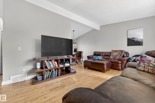 Spacious living area featuring light gray walls, light wood-finish flooring, and a vaulted ceiling - 1 Greenwich Crescent, St. Albert, AB - Indoor Photo Showing Living Room