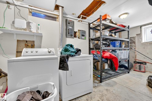 Dedicated laundry area featuring a washer and dryer, adjacent to utility access panels and a storage shelving unit - 1 Greenwich Crescent, St. Albert, AB - Indoor Photo Showing Laundry Room