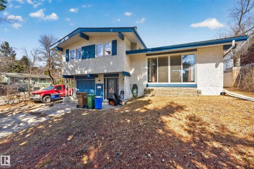 Split-level residence featuring a stucco exterior with blue trim accents - 1 Greenwich Crescent, St. Albert, AB - Outdoor
